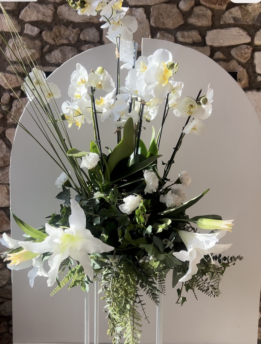 Apportez une touche d'élégance intemporelle à vos mariages, baptêmes, anniversaires et autres célébrations avec nos bouquets blancs sur support sellette. Ces magnifiques arrangements floraux sont présentés sur des supports raffinés, créant une atmosphère chic et sophistiquée qui ravira vos invités. Les bouquets blancs, symbole de pureté et de simplicité, s’adaptent parfaitement à tous les décors, des mariages classiques aux réceptions modernes. Chaque bouquet est minutieusement composé pour garantir sa fraîcheur et son éclat, tandis que le support sellette ajoute une dimension esthétique unique, le mettant en valeur. Utilisez ces créations comme centres de table, décorations de cérémonie ou éléments d'accueil pour impressionner vos convives dès leur arrivée. Que ce soit à l'intérieur ou en extérieur, nos bouquets blancs sur support sellette transforment chaque espace en un lieu enchanteur. Faites de votre événement une célébration mémorable grâce à cette décoration florale alliant charme et élégance.