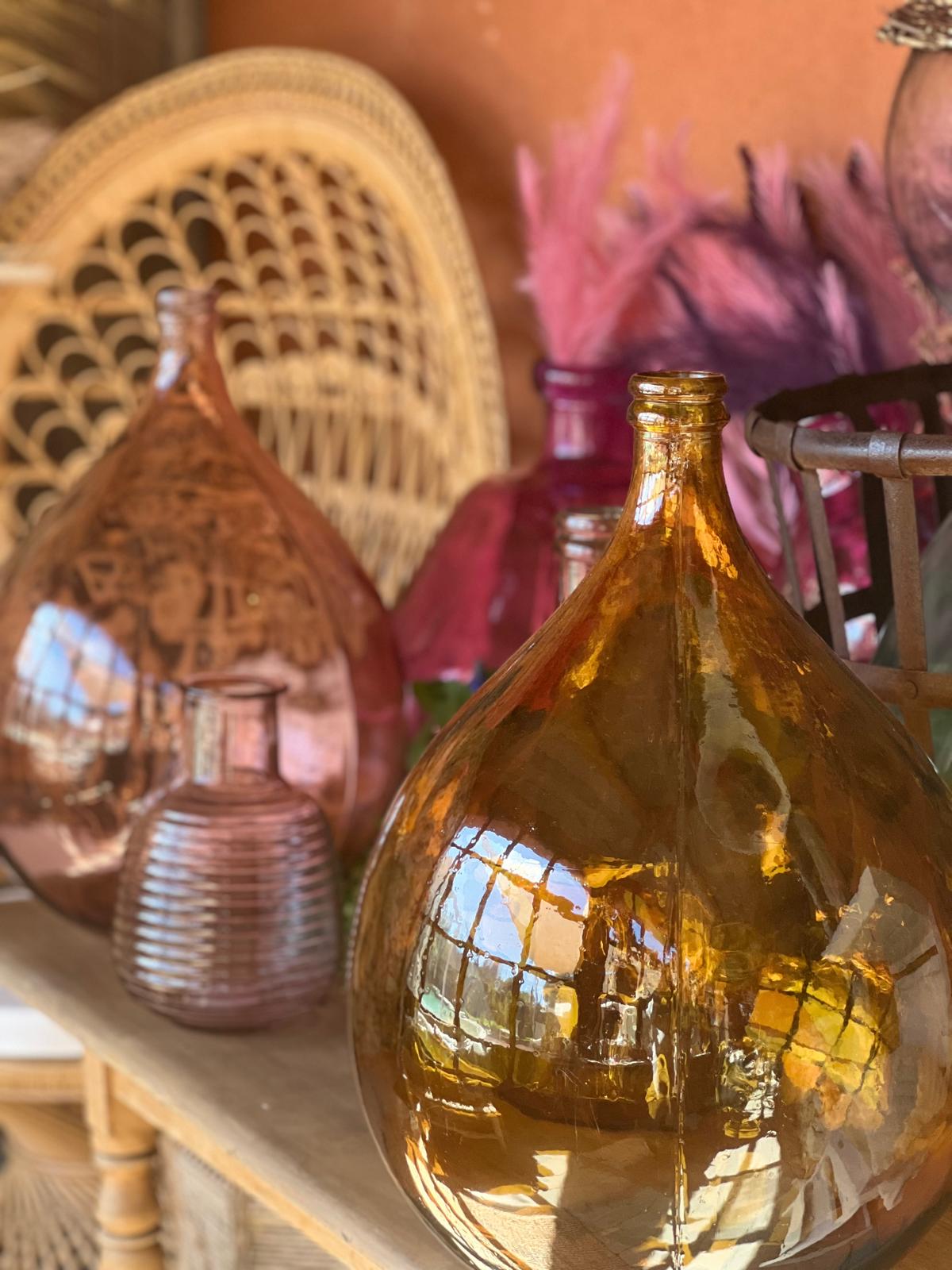 Égayez vos mariages, baptêmes, anniversaires et autres célébrations avec nos dames Jeanne colorées, un élément décoratif à la fois tendance et intemporel. Ces bouteilles en verre soufflé, disponibles dans une palette de couleurs vibrantes, apportent une touche d’élégance et de charme vintage à votre décoration. Utilisées comme vases pour des fleurs fraîches ou comme pièces maîtresses sur vos tables, les dames Jeanne créent une ambiance chaleureuse et accueillante, invitant vos invités à admirer chaque détail. Optez pour ces accessoires décoratifs uniques pour embellir vos événements et laissez une impression durable sur vos convives. Égayez vos mariages, baptêmes, anniversaires et autres célébrations avec nos dames Jeanne colorées, un élément décoratif à la fois tendance et intemporel. Ces bouteilles en verre soufflé, disponibles dans une palette de couleurs vibrantes, apportent une touche d’élégance et de charme vintage à votre décoration. Utilisées comme vases pour des fleurs fraîches ou comme pièces maîtresses sur vos tables, les dames Jeanne créent une ambiance chaleureuse et accueillante, invitant vos invités à admirer chaque détail. Optez pour ces accessoires décoratifs uniques pour embellir vos événements et laissez une impression durable sur vos convives.